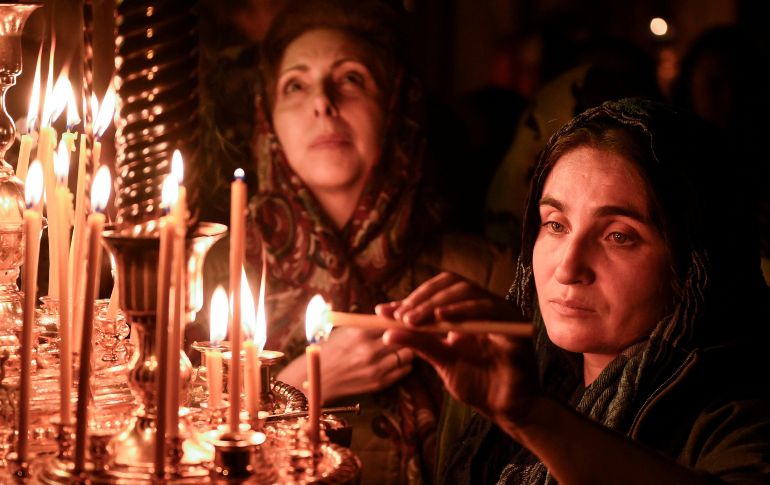 Mujeres encienden velas durante una ceremonia de la Pascua ortodoxa en Bakú, Azerbaiyán. AFP/T. Babayev