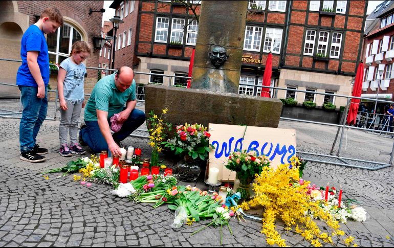 Personas colocan flores en el sitio donde un hombre embistió ayer contra un restaurante al aire libre en Munster, Alemania, matando a dos personas. AFP/J. Macdougall