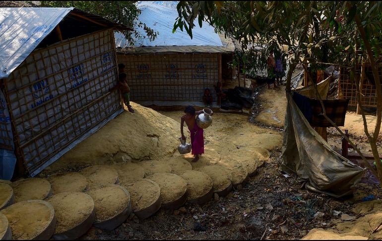 Una refugiada rohinyá se dirige a su casa tras recolectar agua potable en el campamento de refugiados Kutupalong, en Bangladesh. AFP/M. Uz Zaman
