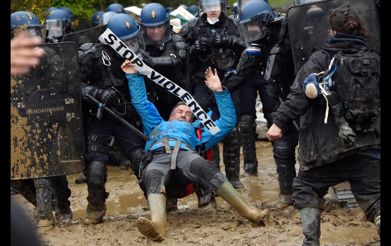 Policías se enfrentan con activistas durante un operativo para expulsarlos de terrenos que ocupan ilegalmente en Notre dame des Landes, Francia, en un sitio donde fue abandonado un proyecto de construcción de un aeropuerto. AFP/L. Venance
