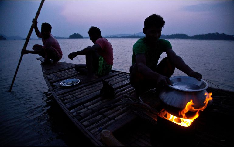 Pescadores preparan alimentos en un bote sobre el río Brahmaputra en la ciudad india de Gauhati. El Brahmaputra es uno de los ríos más largos de Asia. AP/A. Nath