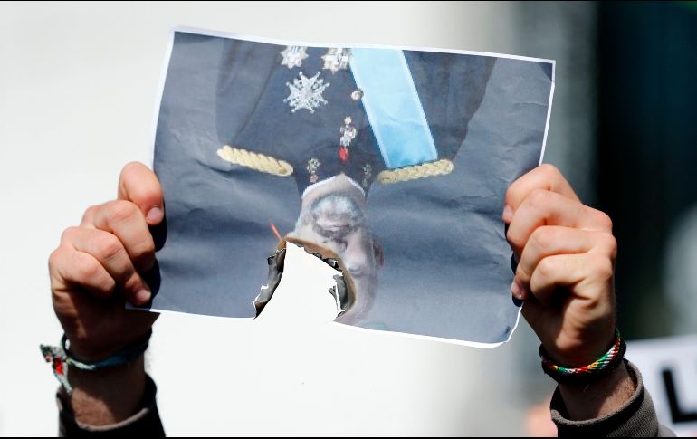 Un hombre quema una foto del rey de España, Felipe VI, en una protesta en contra de la visita del rey a Barcelona, organizada por partidarios de la independencia de Cataluña. AFP/P. Barrena