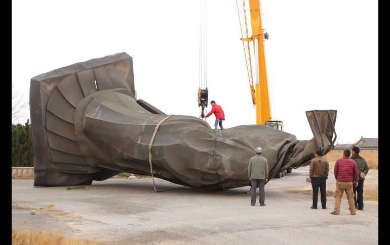 Las autoridades enviaron grúas para levantar la estatua de bronce, de unas seis toneladas de peso, informó el Diario del Pueblo. AFP