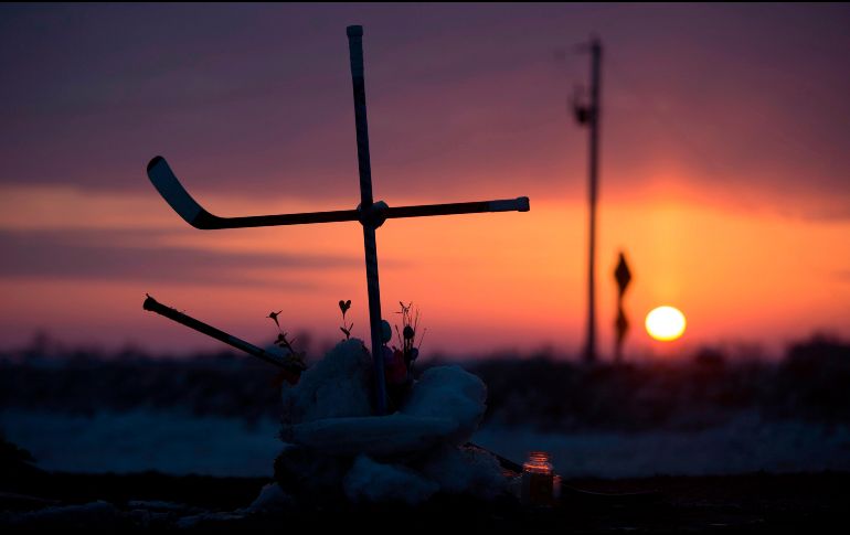 El Sol sale tras una cruz hecha con palos de hockey en Tisdale, Canadá, colocada en la intersección donde el viernes se registró el choque de un camión que trasladaba a un equipo de hockey y que dejó varios muertos. AP/The Canadian Press/J. Hayward