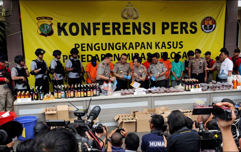 La Policía presentó en la rueda de prensa a seis de las siete personas detenidas, así como varios litros de licor decomisados. AP/T. Syuflana