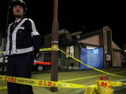 Un oficial vigila la zona donde ocurrió el homicidio. AFP/JIJI