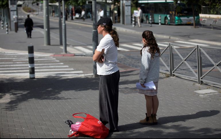 Israelíes permanecen inmóviles durante dos minutos mientras suenan las alarmas antiaéreas para rememorar y honrar a los seis millones de judíos muertos por el nazismo. EFE/A. Safadi