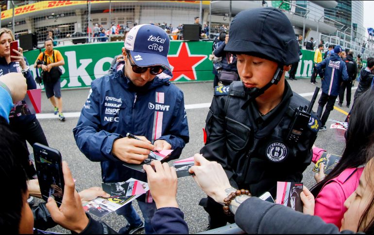 Sergio Pérez firma autógrafos a su llegada al autódromo de Shanghái. EFE/D. Azubel