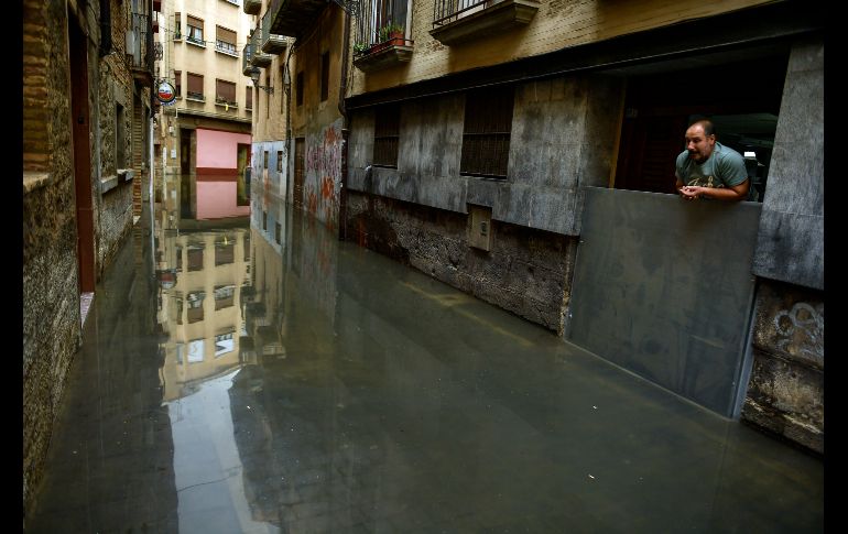Un hombre mira la inundación afuera de su casa en la localidad de Tudela al norte de España, donde las copiosas lluvias han convertido las calles en ríos. AP / A. Barrientos