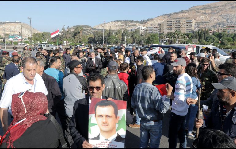 Un hombre sujeta una fotografía de Bachar al Asad durante una manifestación de apoyo. EFE/Y. Badawi