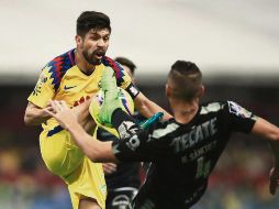 Oribe Peralta y Nicolás Sánchez se muestran las armas en la disputa por el balón. EFE