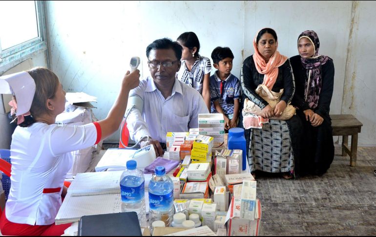 En las imágenes difundidas se ve a la familia siendo sometida a revisión médica, mientras pasan por un proceso burocrático. AFP/MYANMAR NEWS AGENCY