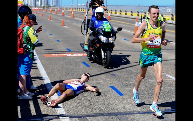 Callum Hawkins, de Escocia, colapsa en el maratón de los Juegos de la Mancomunidad disputados en Gold Coast, Australia. Michael Shelley (d), de Australia, ganó la competencia que previamente lideraba Hawkins. AP/AAP/T. Nearmy