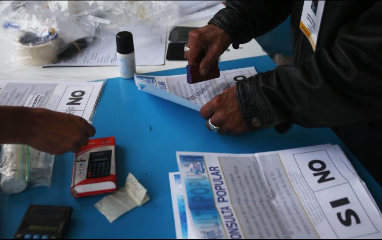 Un voluntario sella papeletas sin usar durante el conteo de votos tras el cierre de los colegios electorales. EFE/E. Biba