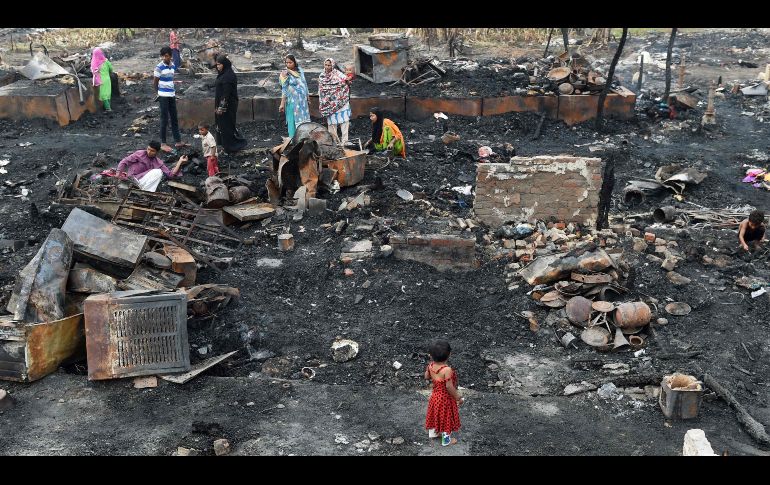 Refugiados rohinyás buscan sus pertenencias en un campamento en Nueva Delhi, India, tras un incendio registrado la víspera, el cual dejó a unas 200 personas sin viviendas. AFP/M. Sharma