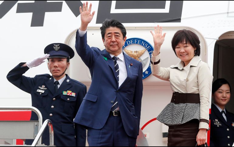 El primer ministro japonés, Shinzo Abe (c), y su esposa Akie Abe (d), saludan en el aeropuerto de Haneda, en Tokio, antes del despegue. EFE/K. Mayama