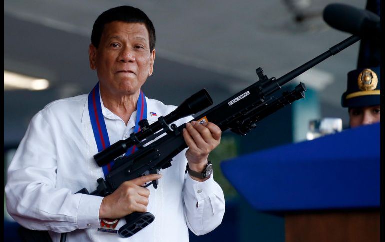El presidente de Filipinas, Rodrigo Duterte, bromea con fotógrafos mientras sostiene un rifle de fabricación israelí, que le dio el director general saliente de la Policía Nacional, Ronald 