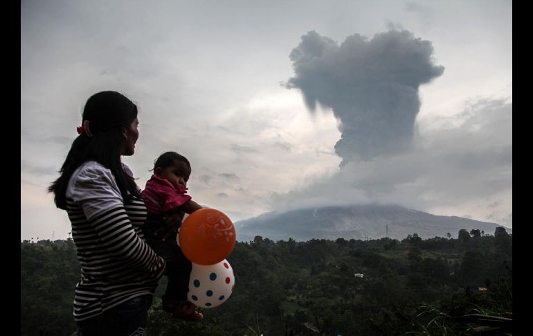 Habitantes observan una erupción del volcán Sinabung desde Karo, Indonesia. AFP/I. Damanik