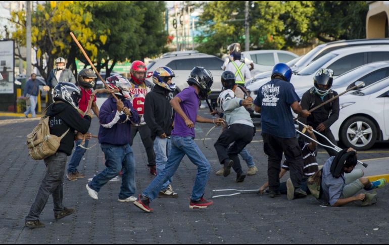 Con los rostros cubiertos y vestidos de civil, miembros de las fuerzas antichoque agredieron a manifestantes y periodistas. EFE/J. Torres