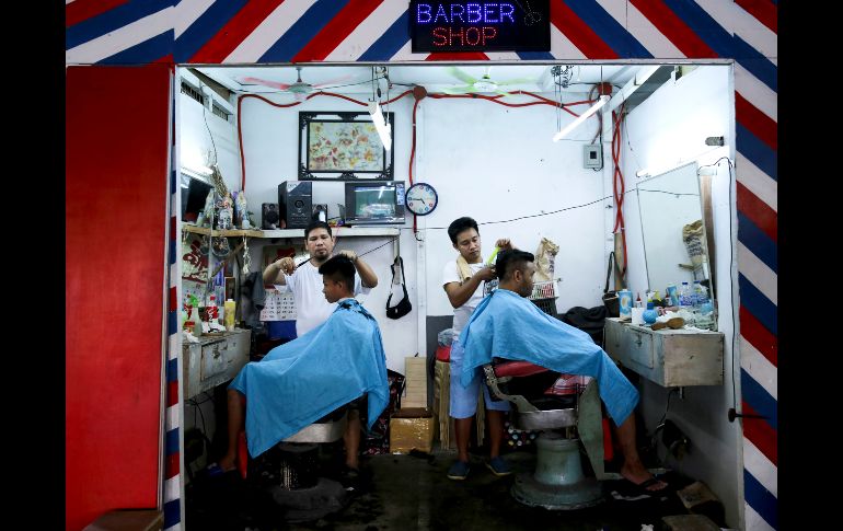 Filipinos se cortan el pelo en una barbería cerca del mercado Balintawak en Manila. AP/A. Favila