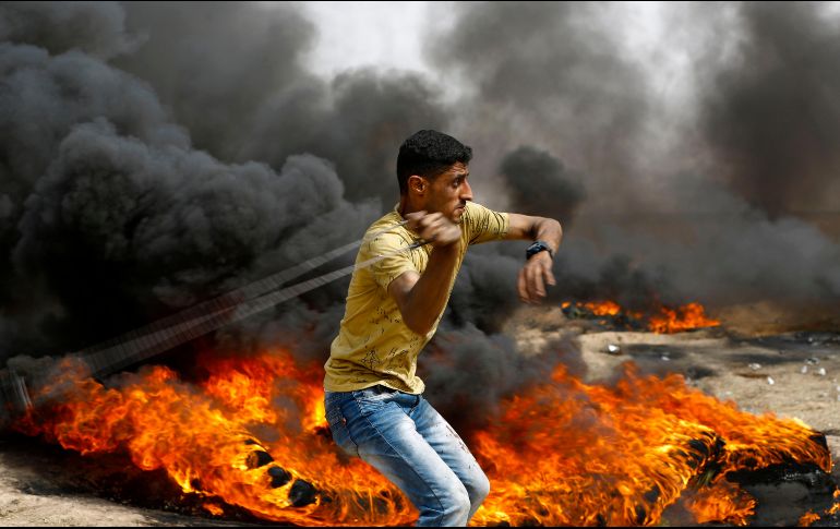 Un palestino se enfrenta con fuerzas de seguridad israelíes en la Ciudad de Gaza, cerca de la frontera con Israel. AFP/M. Abed