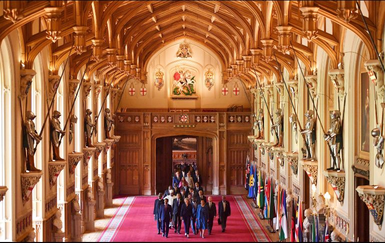 La primera ministra británica Theresa May conduce a otros dirigentes de la Mancomunidad de Naciones por un pasillo del castillo de Windsor, en Inglaterra. El evento reúne a líderes de 53 naciones. AP/PA/B. Stansall
