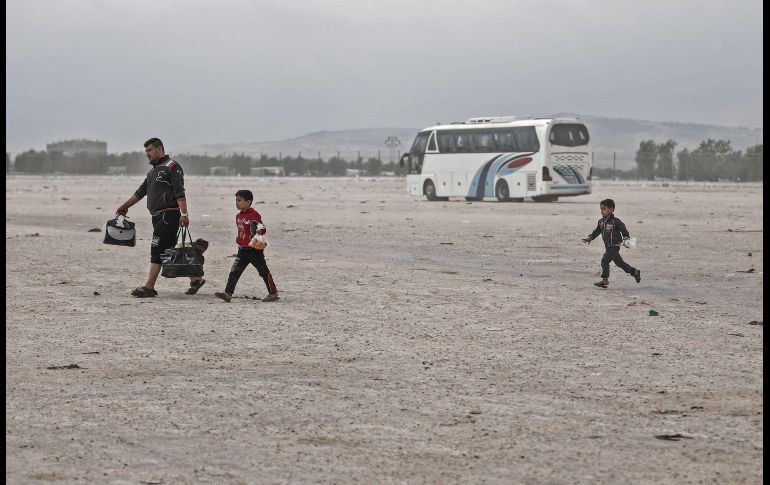 Integrantes de una familia siria evacuada de la población de Dumayr cargan sus pertenencias tras llegar a Azaz. Unos mil 600 combatientes y civiles arribaron a esta última ciudad. AFP/S. Al-Doumy