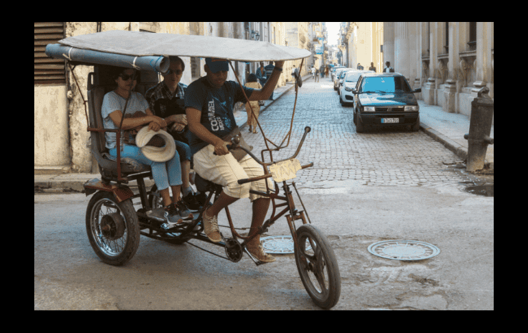 Los usos y costumbres de los cubanos se adaptan a las necesidades: aquí una pareja se transporta en un bicitaxi. EL INFORMADOR/ G. Gallo