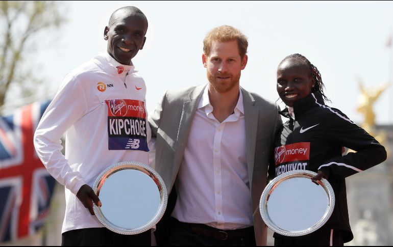 El príncipe Enrique de Inglaterra (c) posa con los kenianos Eliud Kipchoge (i) y Vivian Cheruiyot (d), ganadores del Maratón de Londres, en la capital británica. AP/K. Wigglesworth