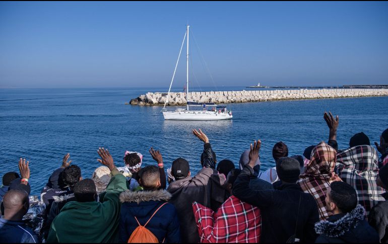 Un grupo de inmigrantes, a bordo del buque de la ONG SOS Mediterranee, saluda a miembros de otra embarcación en la costa de Sicilia, Italia. Cerca de 540 inmigrantes fueron rescatados hoy por miembros de SOS Mediterranee tras tres operaciones. EFE/ C. Petit