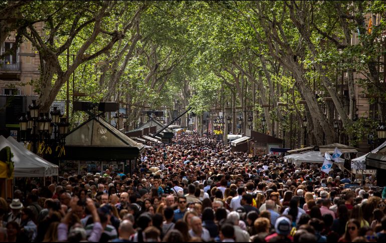 Una multitud inunda el paseo de Las Ramblas en Barcelona. Miles se desplazan por las principales calles de la ciudad española, con una rosa en la mano y en busca del libro para regalar durante la festividad de Sant Jordi. AP/E. Morenatti