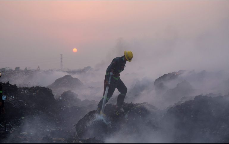 Un bombero combate un incendio en un gran basurero en Rangún, Birmania. AFP/S. Aung Main