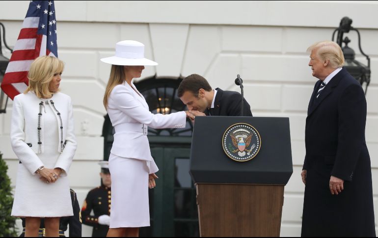 El presidente de Francia, Emmanuel Macron, besa la mano de la primera dama estadounidense, Melania Trump, en una ceremonia de bienvenida en la Casa Blanca en Washington D.C., Estados Unidos. El presidente de Estados Unidos Donald Trump (d) y Brigitte Macron (i) los observan. AFP/L. Marin