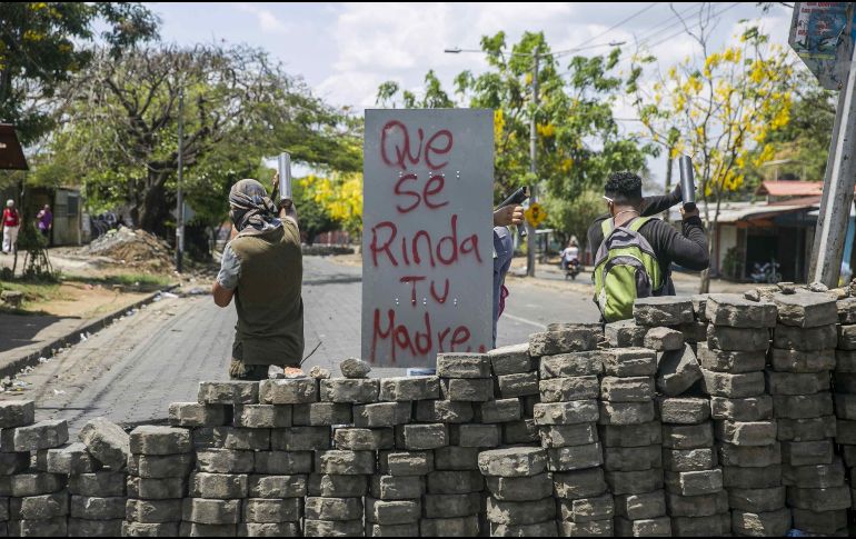 Tres jóvenes cuidan una barricada de adoquines durante el séptimo día de protesta contra el Gobierno. EFE/J. Torres
