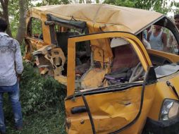 Un grupo de personas observa los restos del autobús escolar después de la tragedia. EFE/STR