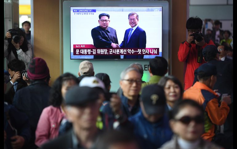 Personas observan en Seúl una transmisión en vivo del encuentro. AFP/Y. Jung