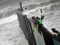 Caravana de migrantes protesta en muro con EU