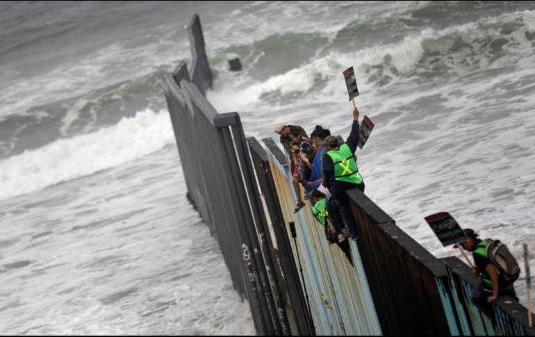 Varios migrantes escalaron la valla fronteriza en donde gritaban 