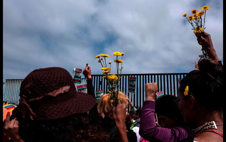 Migrantes se manifiestan este domingo en Tiuana, junto a la valla fronteriza con San Diego. AFP/G. Arias