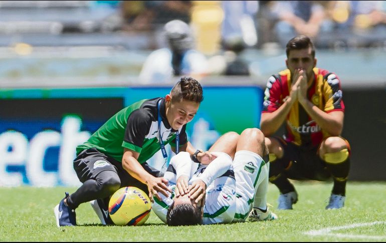 Mientras Néstor Vidrio lamenta la pérdida del campeonato, un jugador de Cafetaleros yace en el césped presa de la emoción de hacerse con el trofeo del Ascenso MX. MEXSPORT