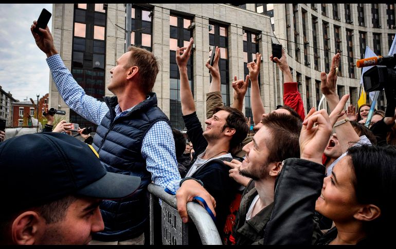 El líder opositor ruso  Alexei Navalny (i) se toma una selfie con manifestantes en Moscú, durante una protesta para exigir libertad de internet en Rusia, luego del bloqueo de Telegram por su negativa a entregar sus códigos. AFP/A. Nemenov