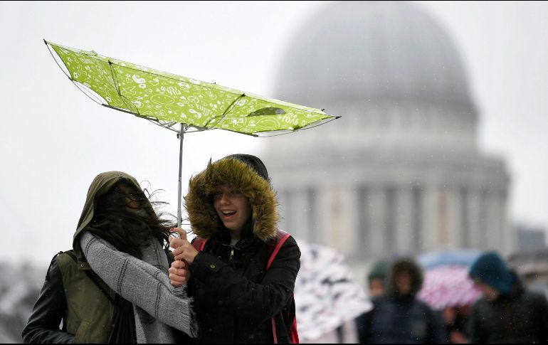 Una joven lucha por controlar un paraguas en los alrededores de la catedral de San Pablo en Londres, en un día lluvioso. EFE/N. Hall