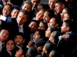 Fotografía de 2014 donde se ve al presidente Enrique Peña Nieto junto a niños cuyo desempeño escolar fue destacado. ESPECIAL