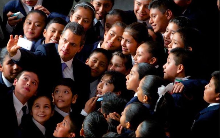 Fotografía de 2014 donde se ve al presidente Enrique Peña Nieto junto a niños cuyo desempeño escolar fue destacado. ESPECIAL