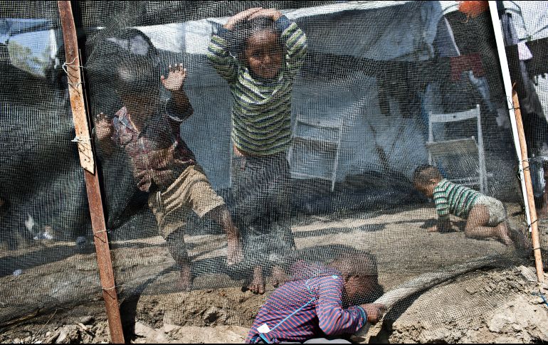 Niños juegan dentro del campamento de refugiados en Lesbos, Grecia. El gobierno ha prometido reducir considerablemente la saturación de los campamentos en la isla durante el verano. AP/P. Giannakouris