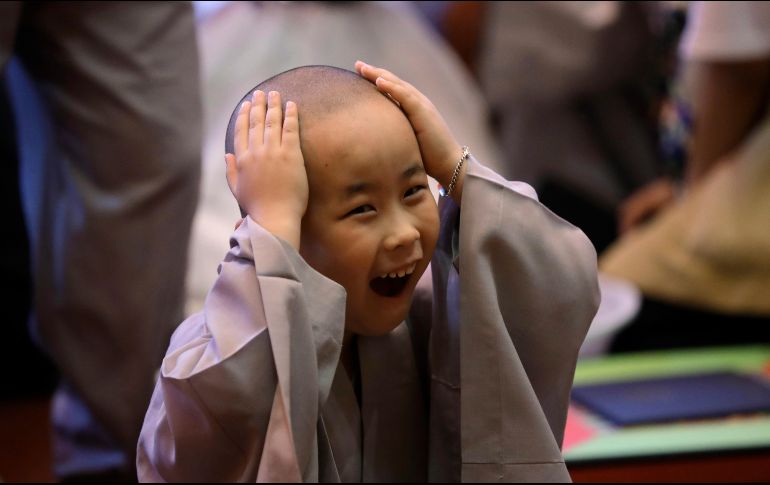 Un niño se toca su cabeza recién afeitada, previo a una ceremonia en el templo Jogye en Seúl, Corea del Sur.  Diez niños pasarán tres semanas para experimentar la vida de los monjes budistas. AP/J. Lee