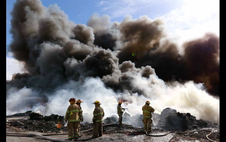 Bomberos, personal de Protección Civil y voluntarios intentan sofocar el incendio de una planta recicladora de desechos en Ciudad Juárez, Chihuahua. No se reportaron heridos, pero se declaró una emergencia ambiental. EFE/A. Bringas
