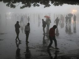 Varias personas caminan bajo fuertes lluvias en la ciudad de Shimla, en el estado de Himachal Pradesh. AFP