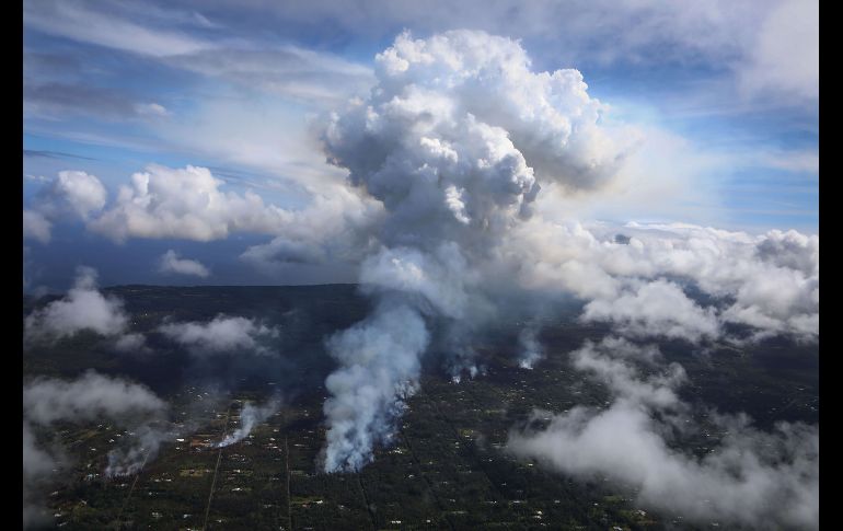 Una pluma de gas y humo se eleva entre las nubes en la isla. Su cumbre se halla a mil 250 metros por encima del nivel del mar y en la cima está el cráter Halema'uma'u, con uno de los dos lagos de lava más grandes del mundo. AFP/M. Tama