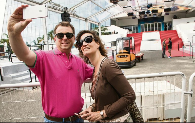 No más selfies. Un par de turistas se toman selfies durante el montaje de una alfombra roja en Cannes. Dicha acción estará prohibida para los artistas. AP